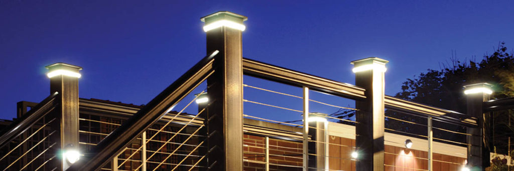 Deck post lights beneath the cap on a black composite railing