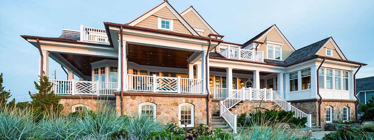 Premium Photo  A cozy modern home with a rustic touch featuring a large  stone fireplace and a wraparound porch