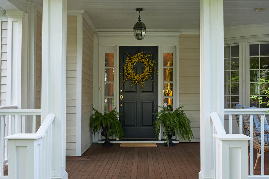 Traditional-style front porch designs feature a stately entryway with AZEK Exteriors column wraps