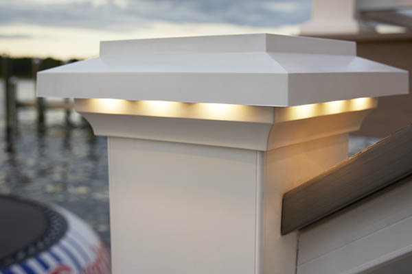 Close-up image of a white composite railing post cap with a lighted island cap