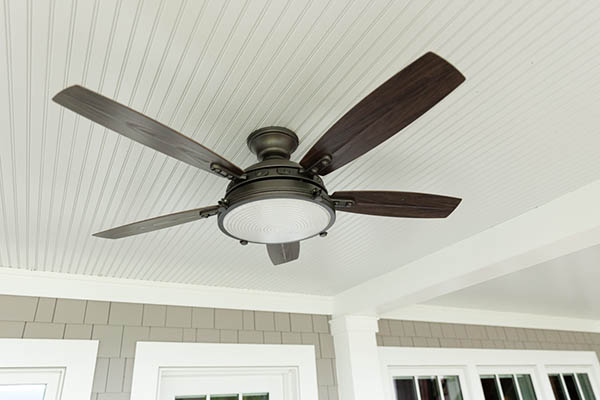 A beadboard ceiling and ceiling fan add style and function to a porch roof