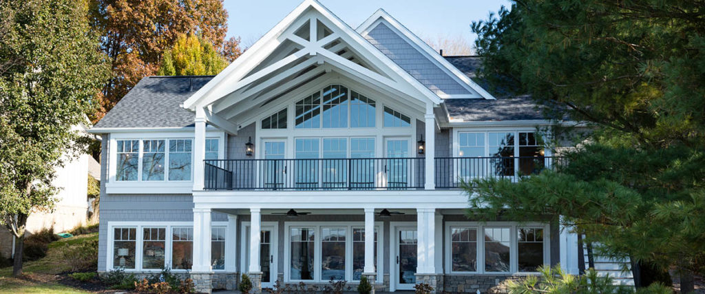 A craftsman-style porch remodel featuring crossbeams on a pitched gable roof extension