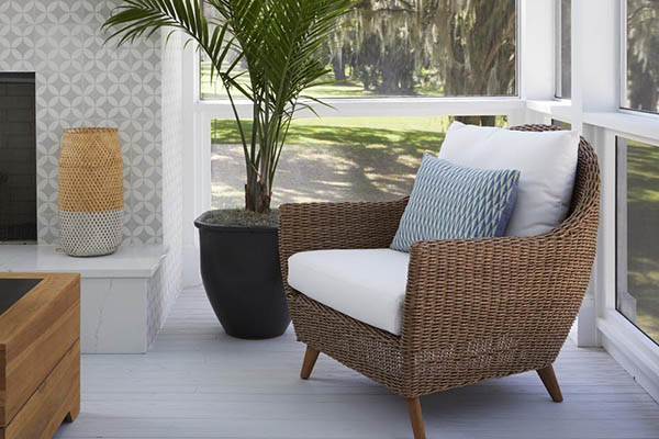 Natural textures like a wicker chair adds to the coastal vibe of this porch