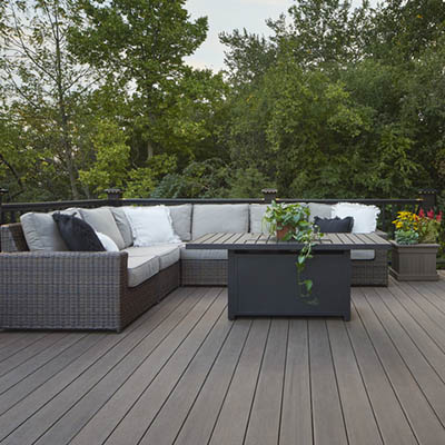A richly hued composite deck features an L-shaped couch in the corner