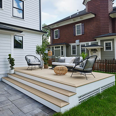 A small composite deck with Weathered Teak decking features black and white furniture