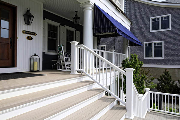 A nautical-inspired home features modern front porch ideas like echoed white elements on home and porch