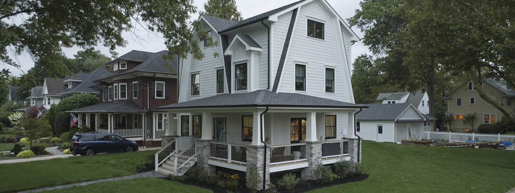 A Scandinavian-style home features modern front porch ideas like a wraparound porch