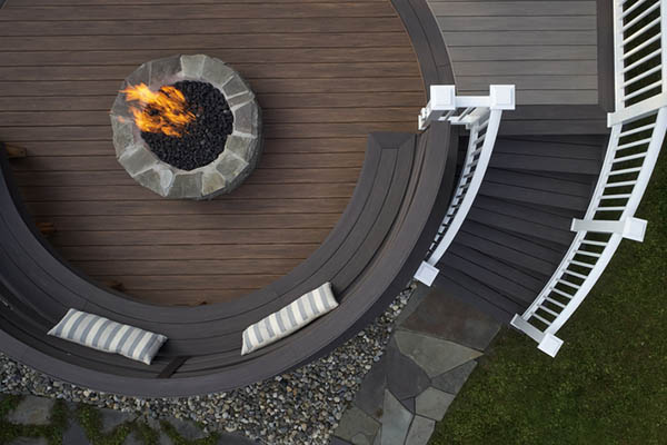 Backyard deck design ideas include a curved built-in bench around a circle inlay