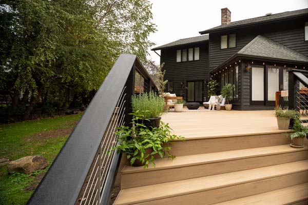 A black composite railing with a flat board top rail on a sprawling modern composite deck