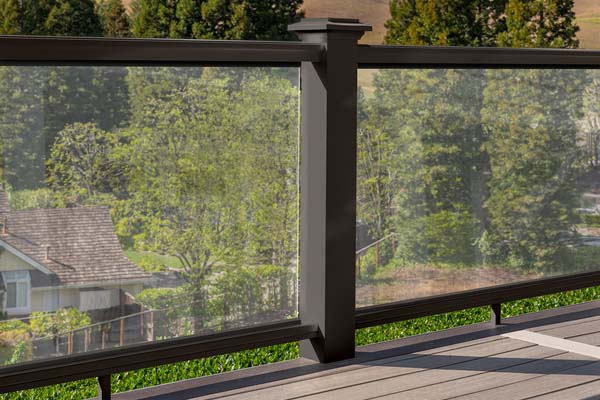 A composite railing in a rich matte espresso color with glass panel infills on a high rise deck