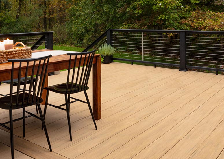 An outdoor dining set sits on the composite deck of Bre from BrePurposed