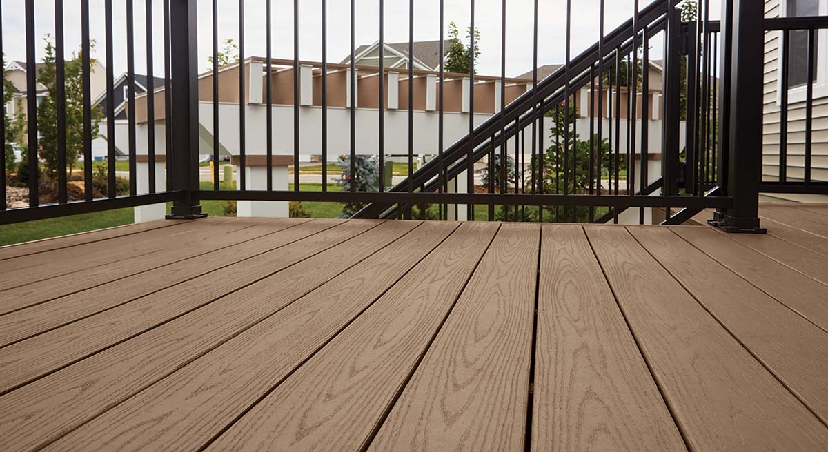Detail shot angled upwards of Classic Brown decking with a black railing in the background