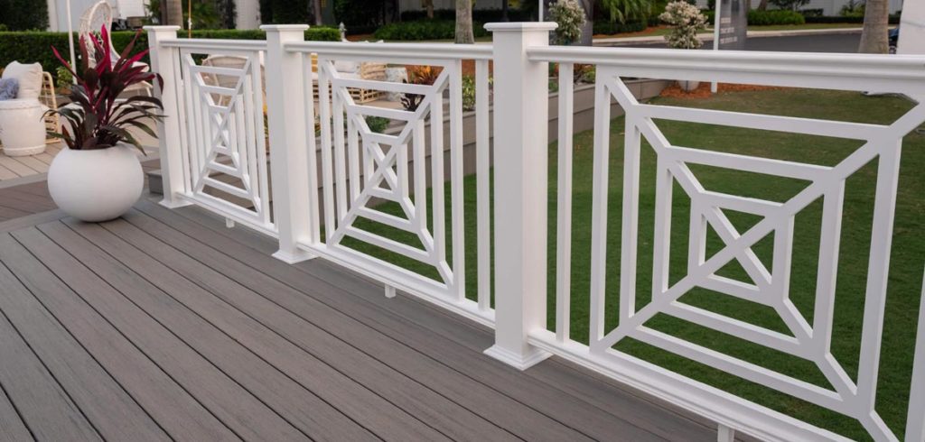 Three white square web panels seperate a deck and lawn with a repeating geometric square pattern. 