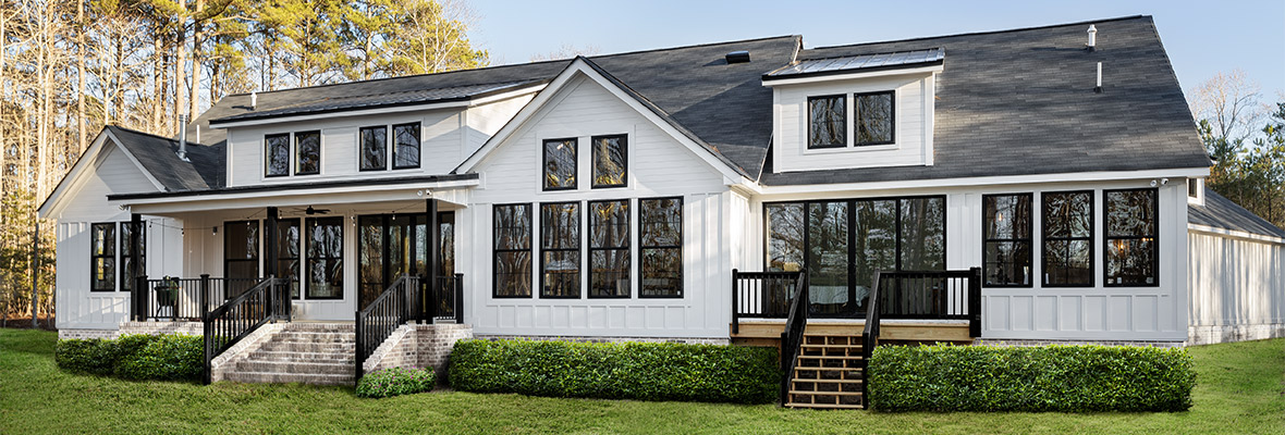 A beautiful, white home with new trim and fresh landscaping faces the camera.