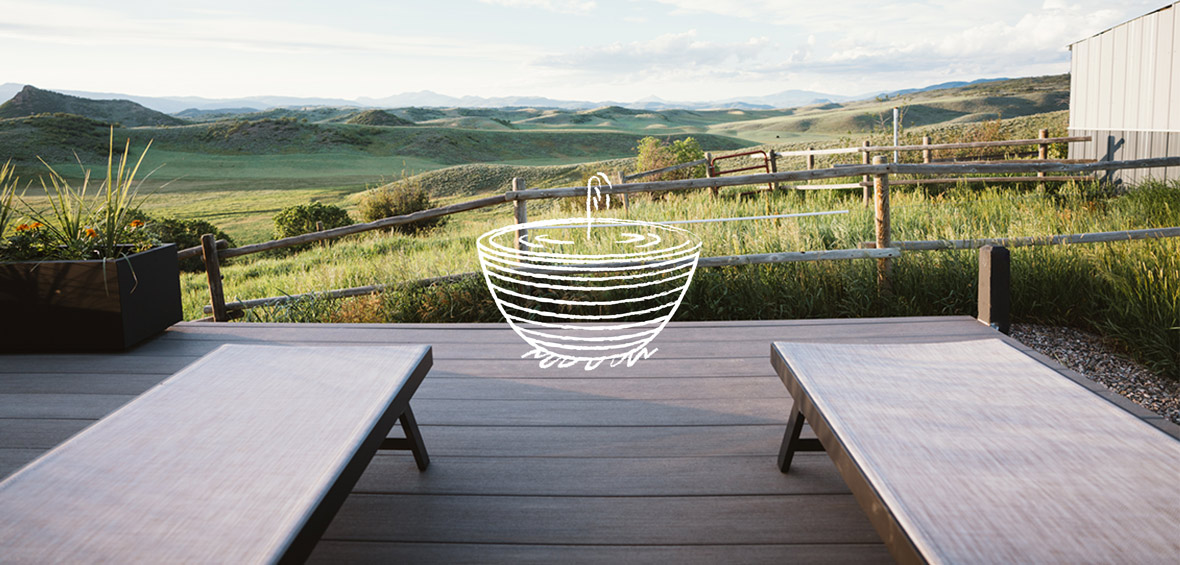 An outdoor deck next to a grassy pasture includes an illustration of a fountain.