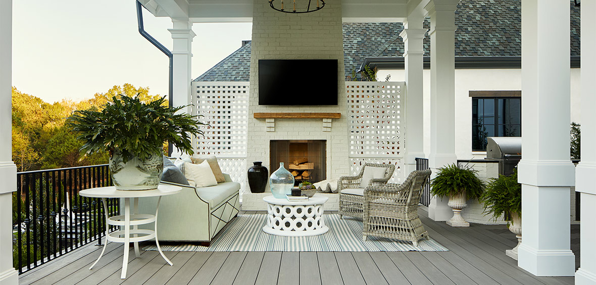 Deck with white lattice, brick-faced fireplace, and woven furniture showcases several textures. 
