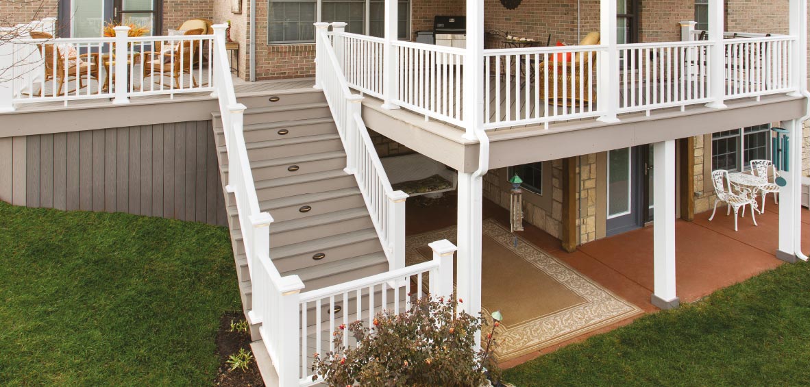 A raised deck over a lower patio shows furniture on each level with a connecting staircase.