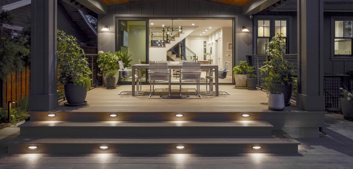 A back deck at night showcases built-in lights on each step for safety and aesthetic.