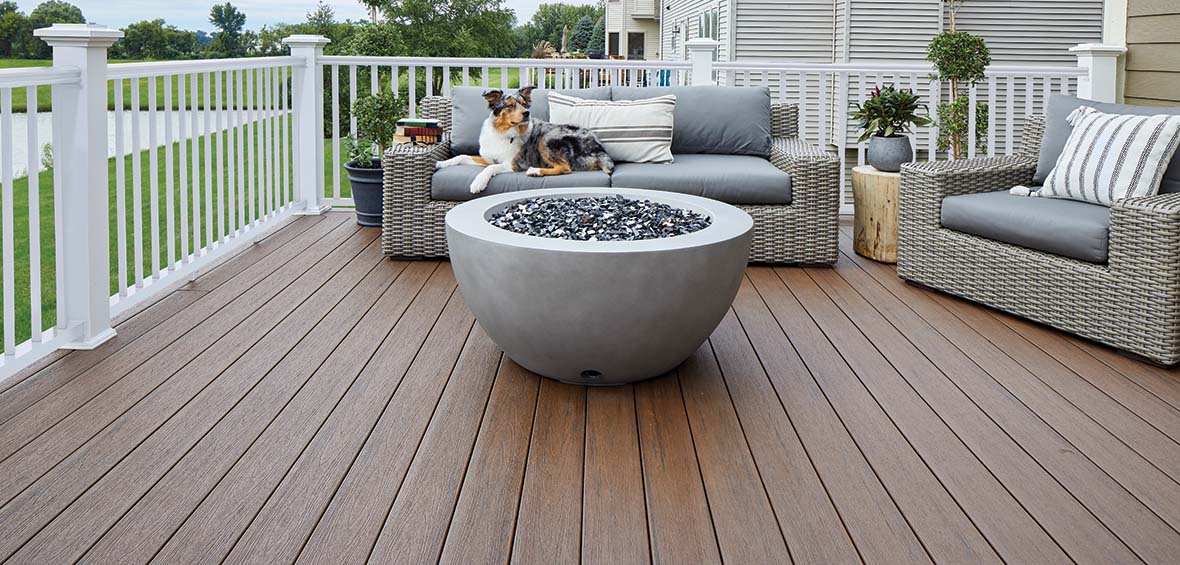 Outdoor seating is backed against the deck’s railing and surrounds a fire pit with plenty of floor space surrounding the layout