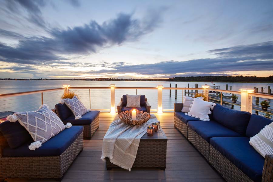 Nighttime shot of a deck on the water with white railing