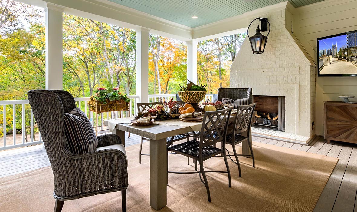 A loggia setup includes an elegant dining area, fireplace, and television.