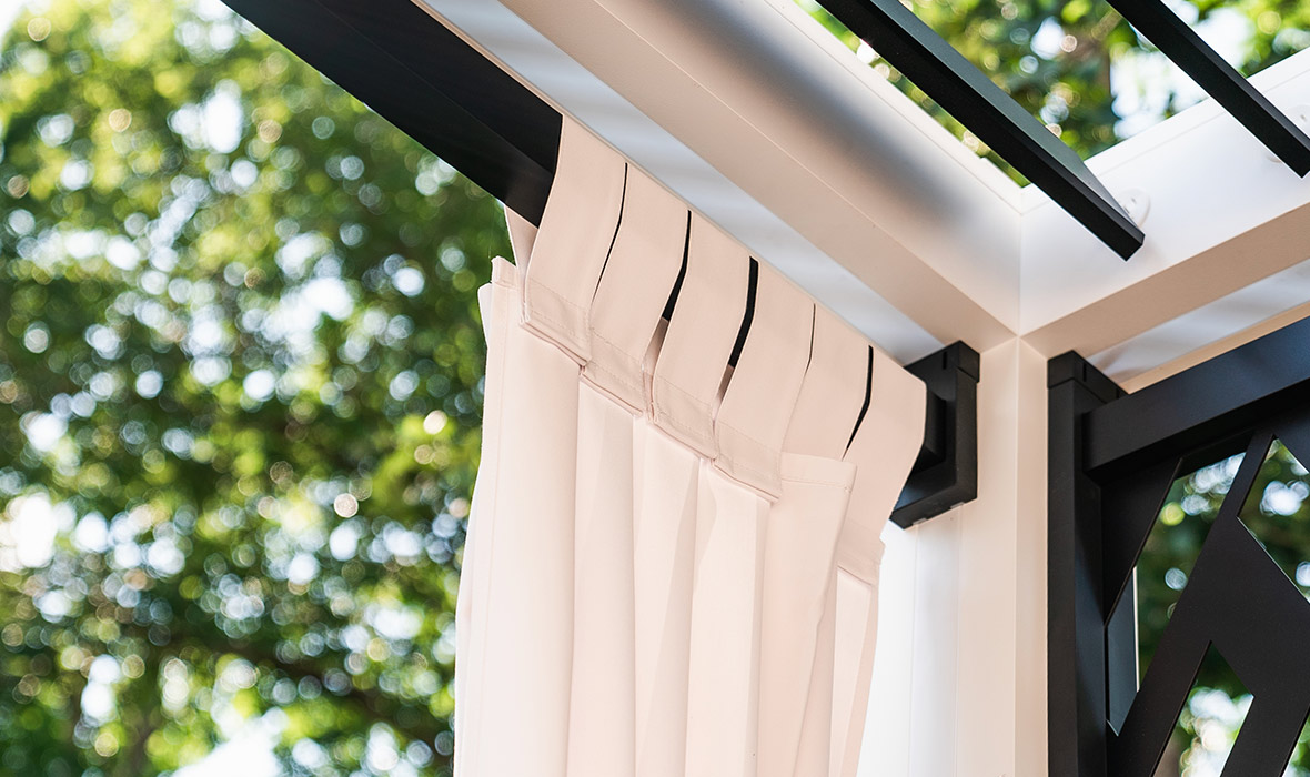 A cabana has extra sun protection in the form of wraparound curtains.