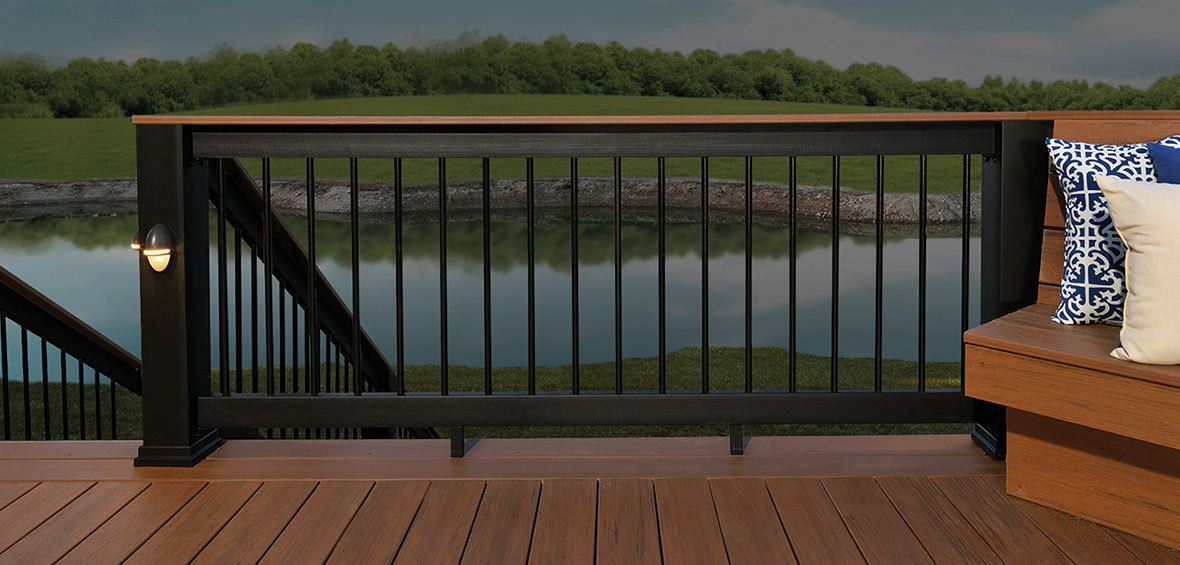 The view from a deck shows a large backyard pond feature on the other side of the guardrail. 