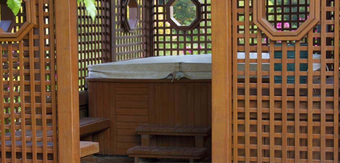 Trellis walls encase a covered hot tub to provide shade and privacy. 