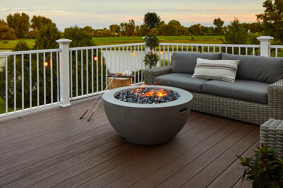 Dark brown deck with an outdoor sofa and a contained fit pit