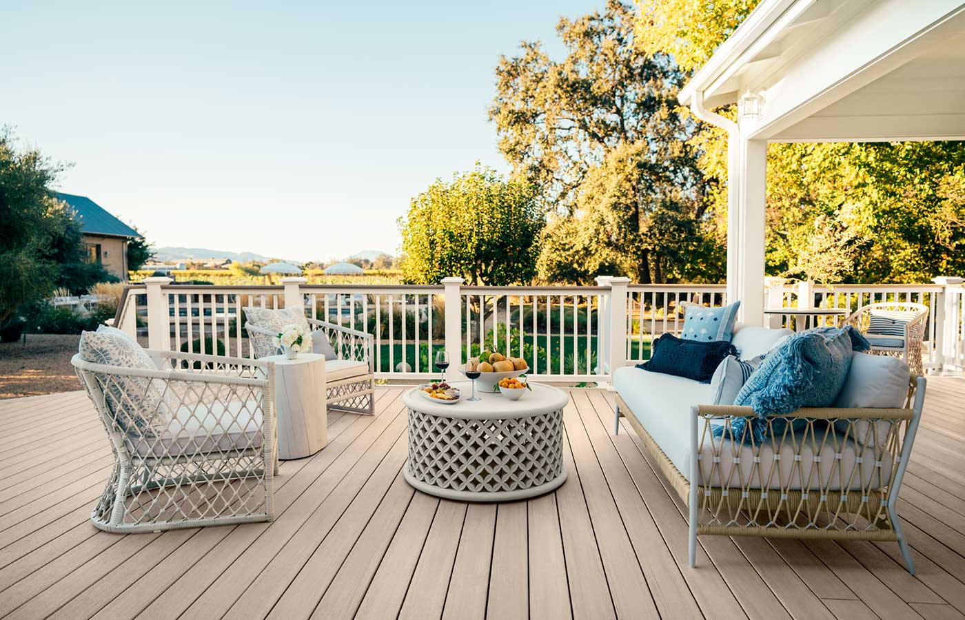 Two chairs and an outdoor couch face each other, a coffee table separates the furniture