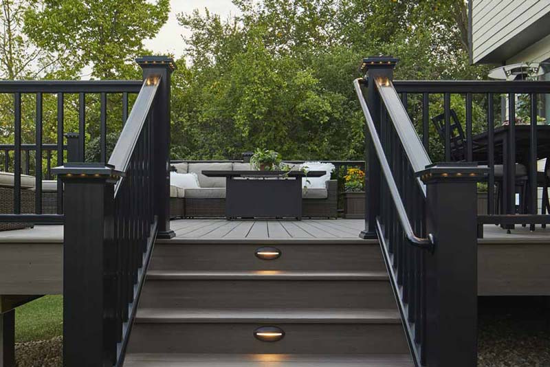 Deck with stairs, built-in riser lights, and a sleek black railing