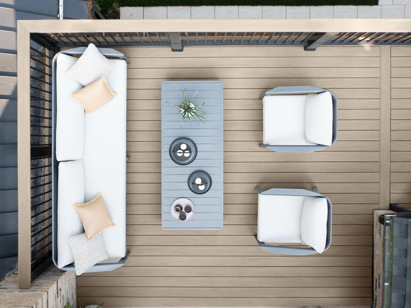 Direct overhead shot of a light gray deck with couch and coffee table