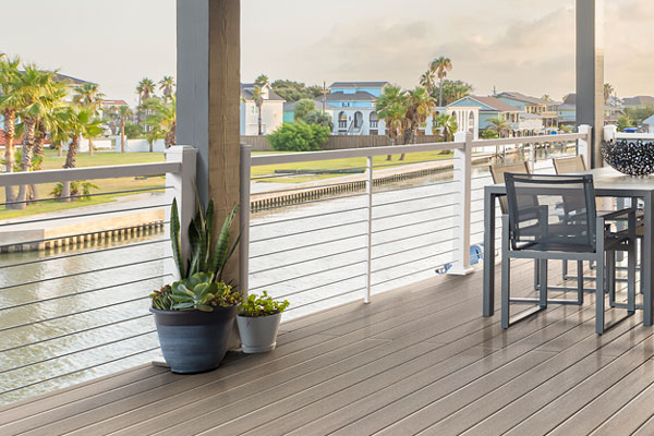 Impression Rail Express Railing with a horizontal cable infill on a light tan colored deck
