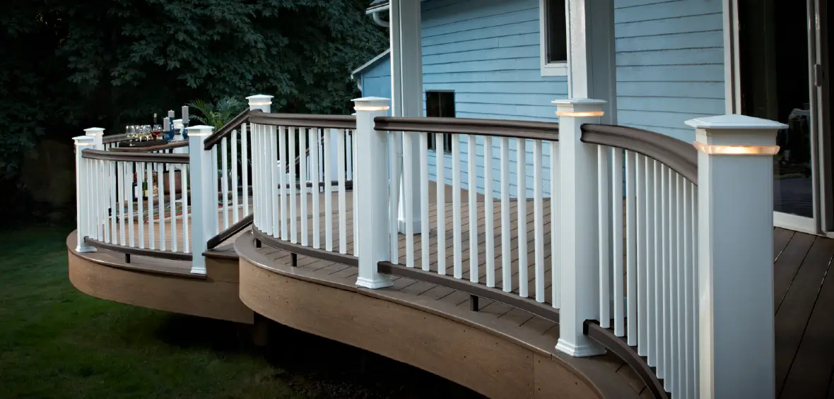 White railing curved in waves to follow the perimeter of a curved, multi-level deck.