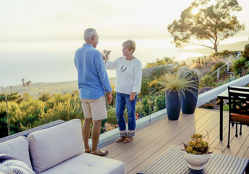 Mark and Jennifer toast with their beverages at sunset on their TimberTech deck