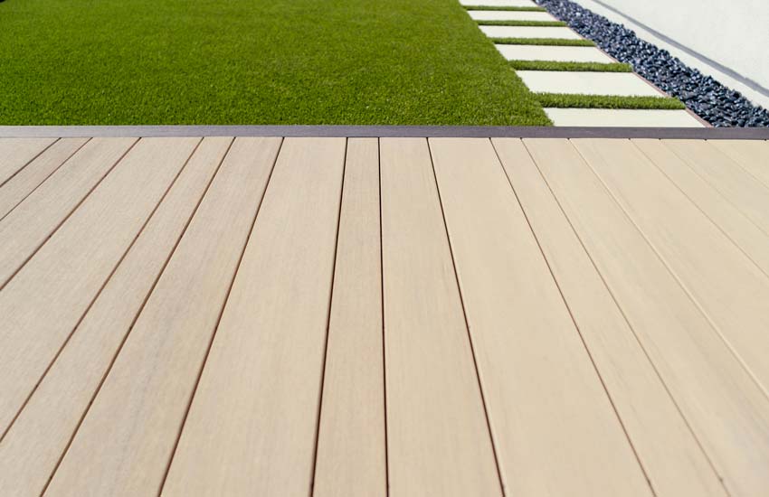 An up-close shot of multiwidth deck boards in Weathered Teak with a border in the Dark Hickory color