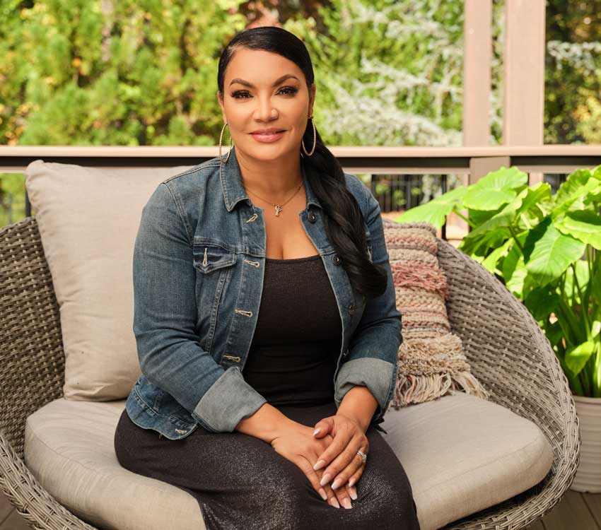 Egypt Sherrod poses for a headshot on her porch, smiling gently
