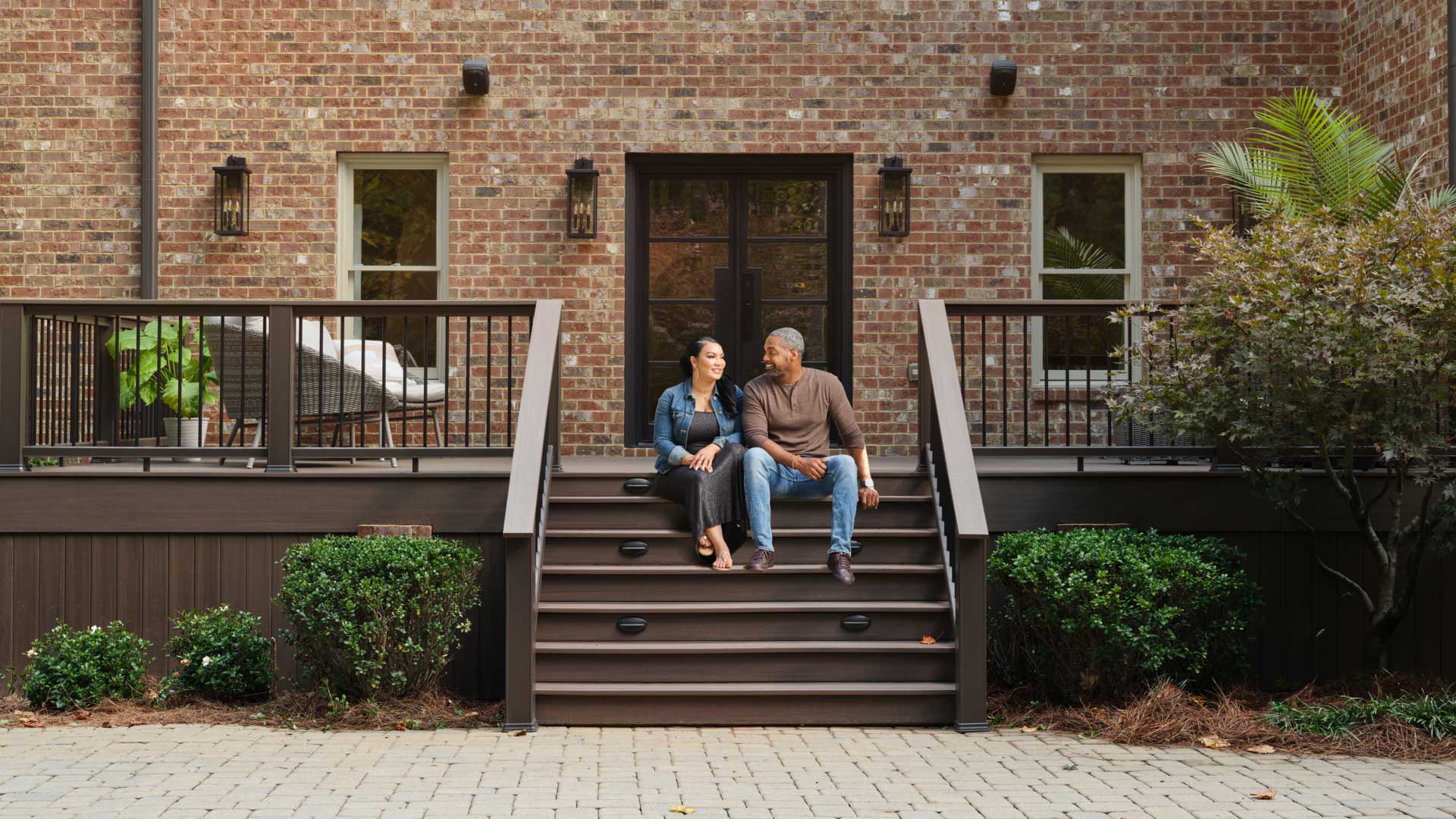 Egypt and Mike, hosts of HGTV's Married to Real Estate, share a quiet moment on the steps of their new outdoor living space