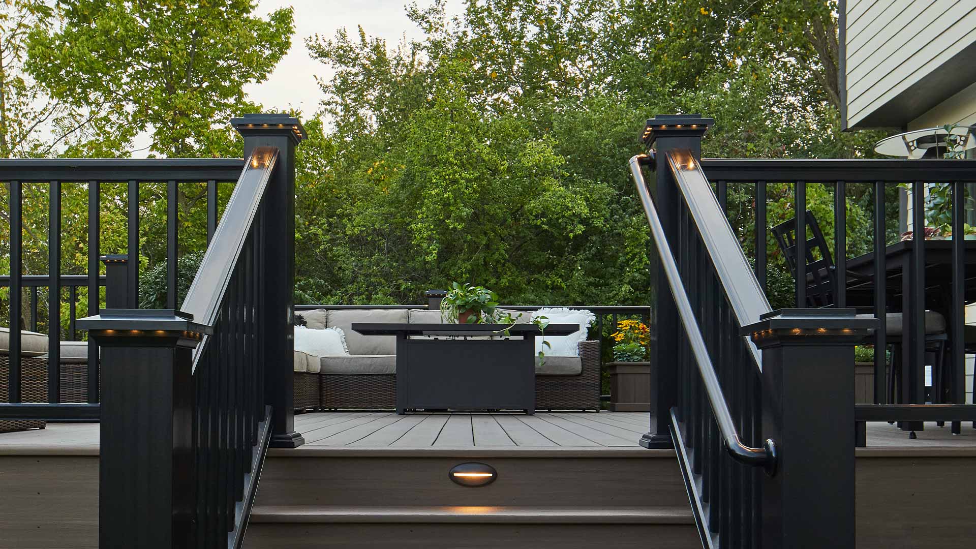 Black deck railing with lighted island caps and gray deck