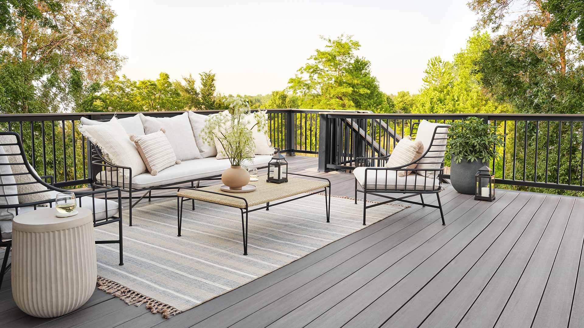 Outdoor furniture on a gray deck with black railing