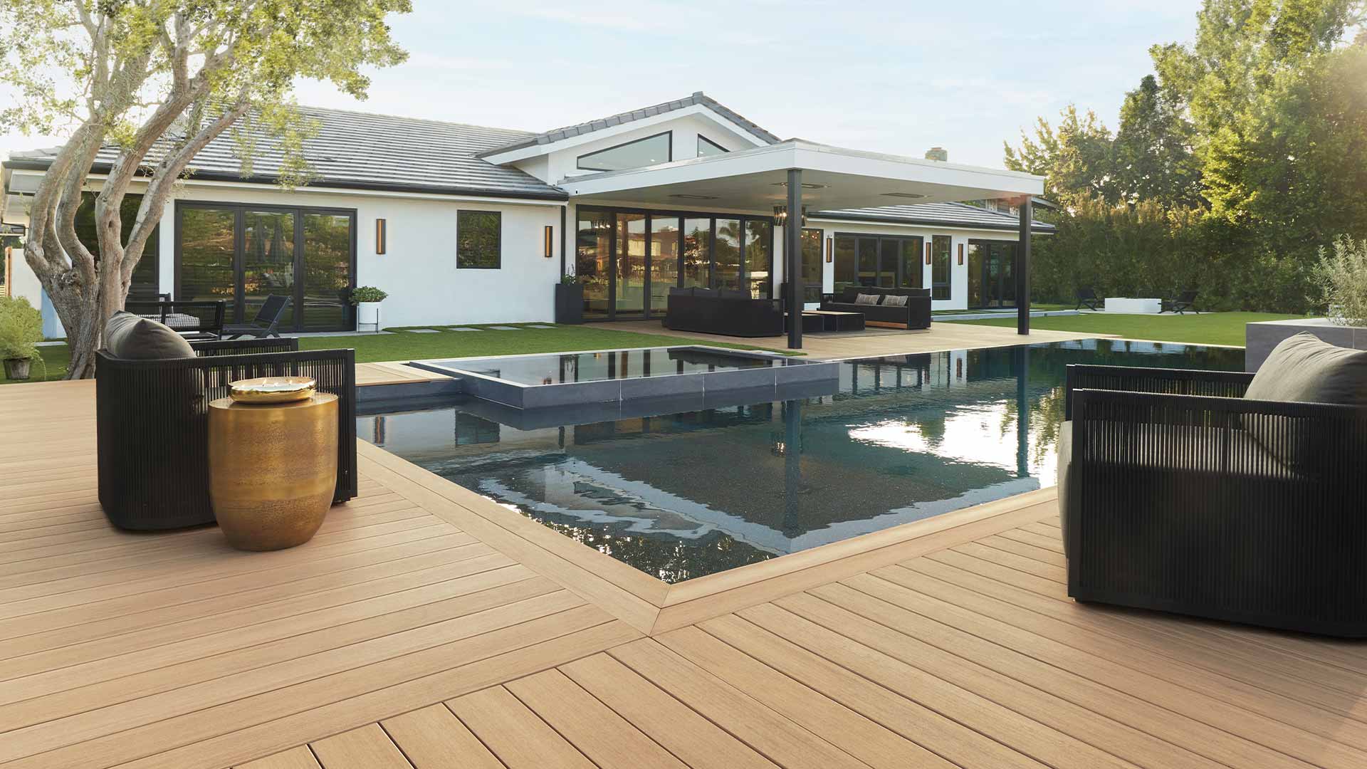 Sunken pool in backyard of house with light brown deck