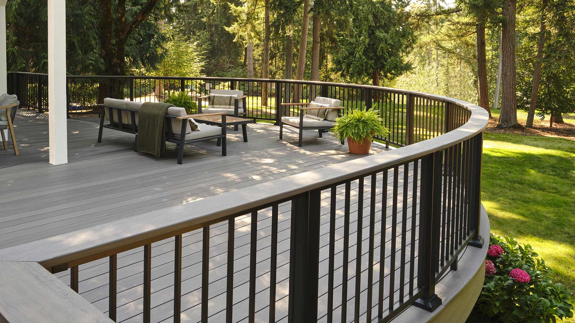 Curved deck with numerous outdoor chairs surrounded by trees