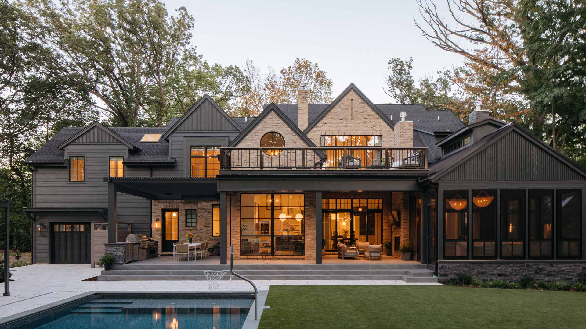 A historic brick home with painted black additions and a multi level outdoor living space