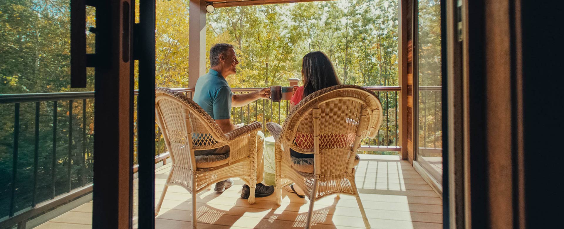 Mike and Lori look comfortable sitting on their deck in the early morning light, the two toast with coffee mugs