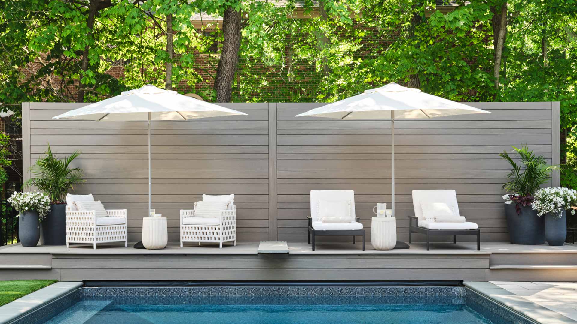 Sunken pool with a privacy wall built with light gray TimberTech boards