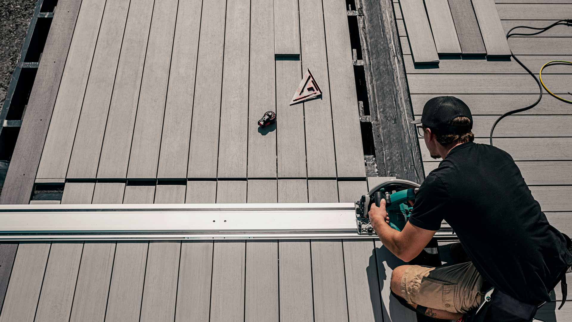 A TimberTech contractor uses a circular saw to cut deck boards to size