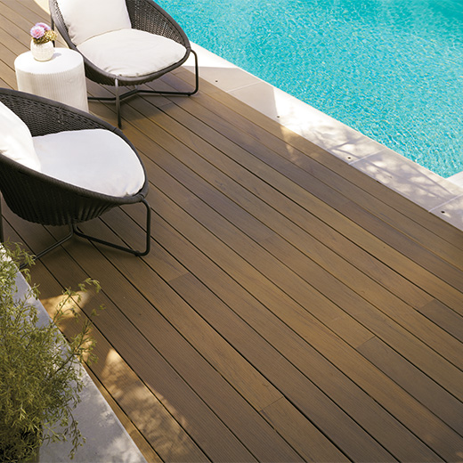 A brown deck near a pool.