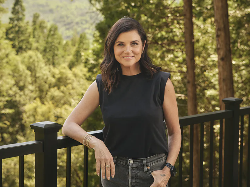 Tiffani Thiessen leans on the railing of her new deck