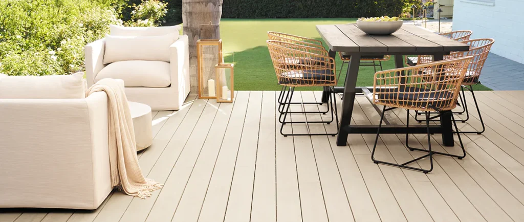 French White Oak light tan deck with outdoor armchairs and a dining room table set up