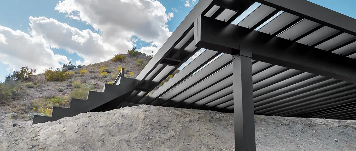 View of the underside of TimberTech Aluminum Framing built into a hill in the desert.